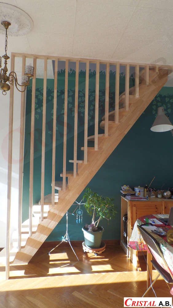 Escalier en bois clair avec garde-corps en tasseaux verticaux toute hauteur. Intérieur design par Cristal A.B.