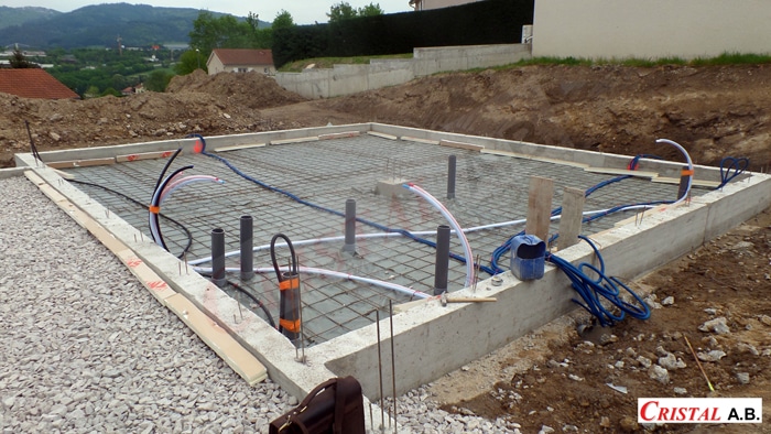 Fondations de maison avec tuyaux PVC et treillis sur un chantier CRISTAL A.B. en cours de réalisation.