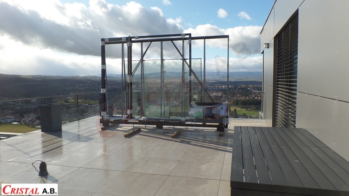 Installation de baies vitrées Cristal A.B. sur une terrasse panoramique moderne avec vue dégagée sur la vallée.