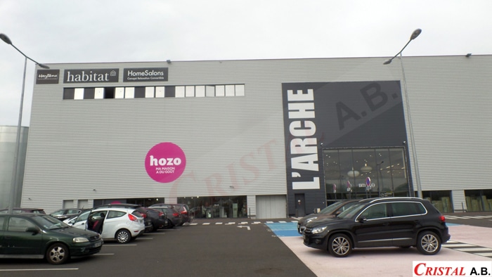 Magasin L'Arche avec enseignes Habitat, HomeSalons et Hozo Ma Maison a du Goût sur façade grise avec parking.