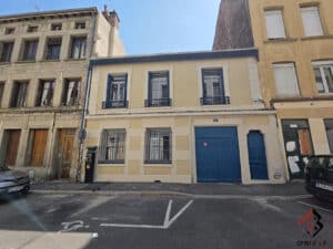 Maison jaune n°4, volets bleus, rue urbaine avec voitures et logo Cristal AP.